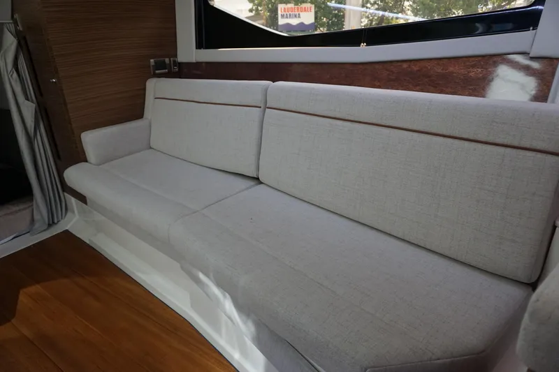 Slide: The Image of Interior seating of 2025 Boston Whaler 365 Conquest, featuring a comfortable beige sofa. - 55