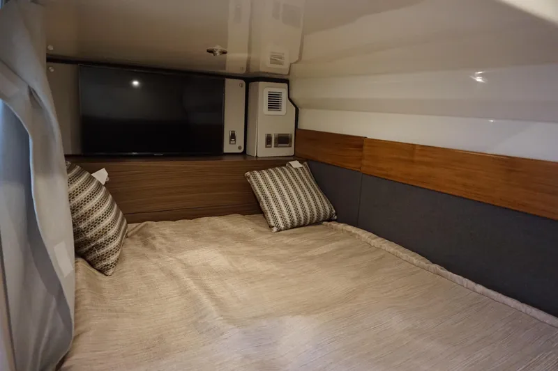 Slide: The Image of 2025 Boston Whaler 365 Conquest cabin interior with cozy bedding and pillows. - 57