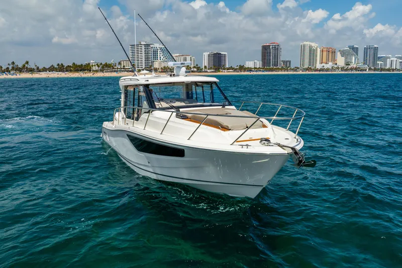 Slide: The Image of 2025 Boston Whaler 365 Conquest cruising near a city skyline on a sunny day. - 7