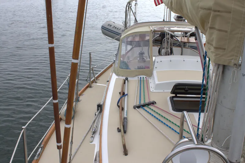 Slide: The Image of 1980 Bristol 35.5 sailboat deck with ropes and equipment, docked on calm water. - 12