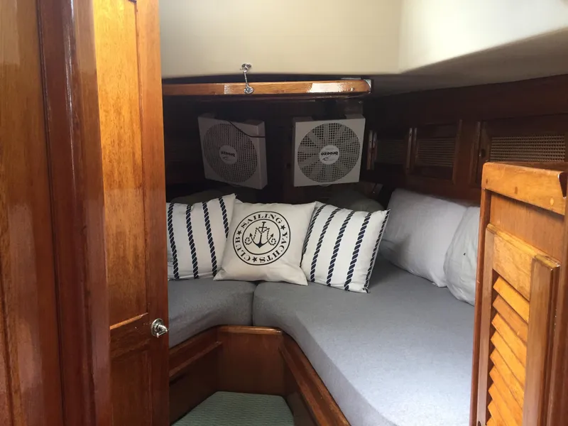 Slide: The Image of 1980 Bristol 35.5 boat cabin with cozy bedding and wooden interior. - 25