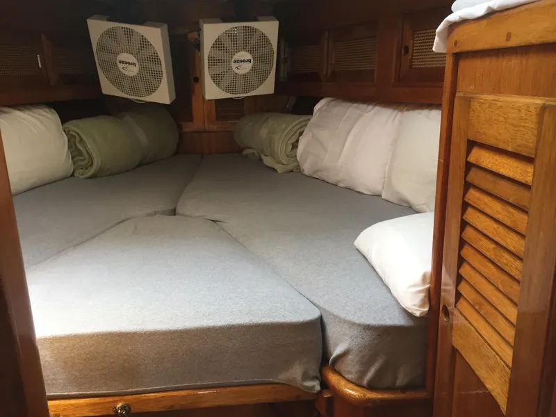 Slide: The Image of Cozy sleeping quarters in a 1980 Bristol 35.5 sailboat with fans and pillows. - 28