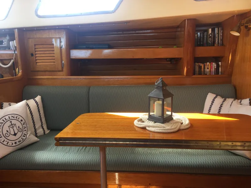 Slide: The Image of Interior of a 1980 Bristol 35.5 sailboat with cozy seating and a lantern on the table. - 30