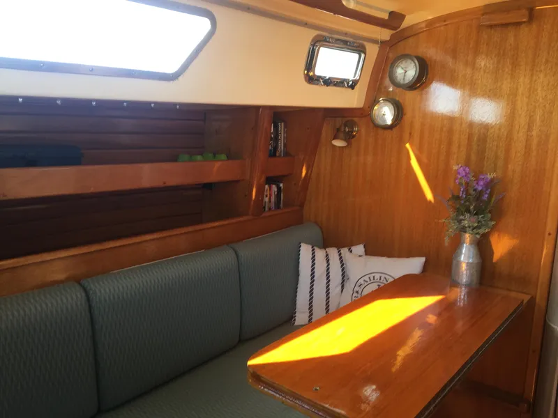 Slide: The Image of 1980 Bristol 35.5 sailboat interior with wooden finish, cozy seating, and nautical decor. - 31