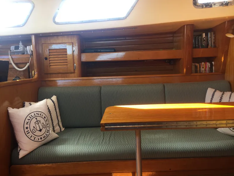 Slide: The Image of Interior of a 1980 Bristol 35.5 sailboat with cushioned seating and wooden table. - 32