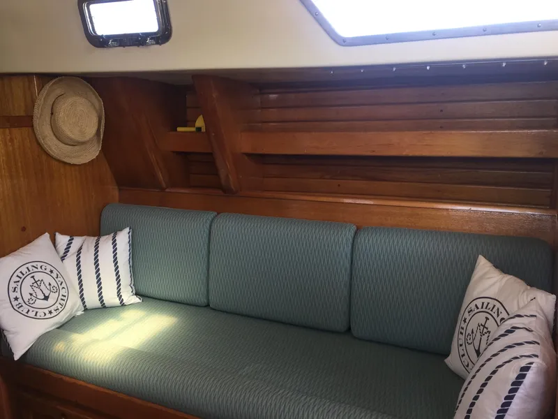 Slide: The Image of 1980 Bristol 35.5 sailboat interior with green cushions and nautical-themed pillows. - 34