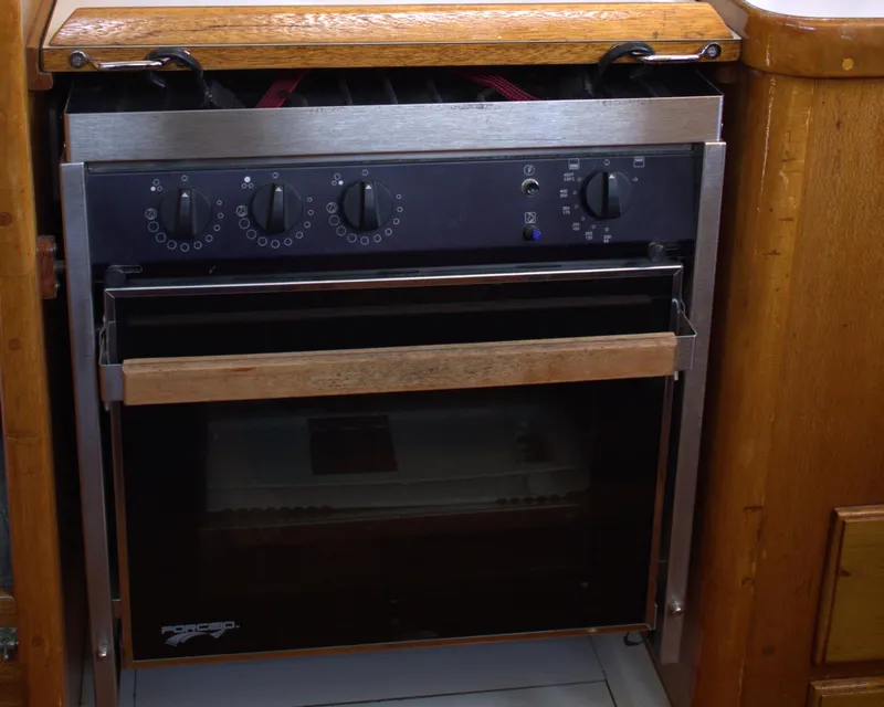 Slide: The Image of 1980 Bristol 35.5 boat kitchen oven with wooden trim and control knobs. - 37