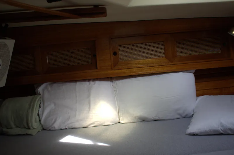 Slide: The Image of Interior cabin of a 1980 Bristol 35.5 sailboat with wooden paneling and bedding. - 44