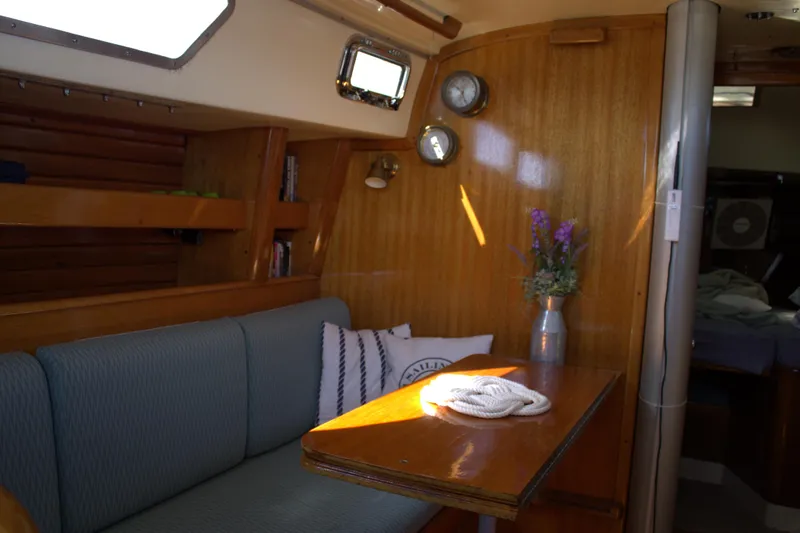 Slide: The Image of Interior of 1980 Bristol 35.5 sailboat with wooden paneling and cozy seating area. - 48