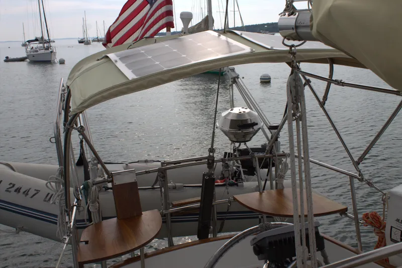 Slide: The Image of 1980 Bristol 35.5 sailboat with solar panel and American flag, docked in a marina. - 5