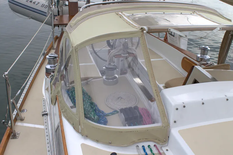 Slide: The Image of 1980 Bristol 35.5 sailboat cockpit with beige canvas cover and clear windows. - 6