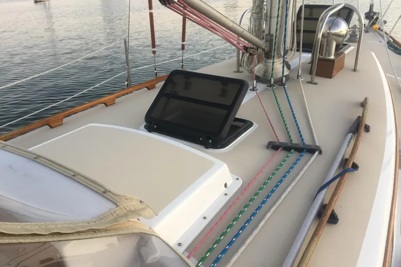 Slide: The Image of 1980 Bristol 35.5 sailboat deck with open hatch and colorful ropes. - 8