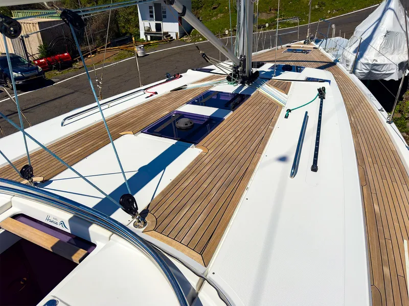 Slide: The Image of 2014 Hanse 445 sailboat deck with teak wood finish and clean white surfaces. - 12