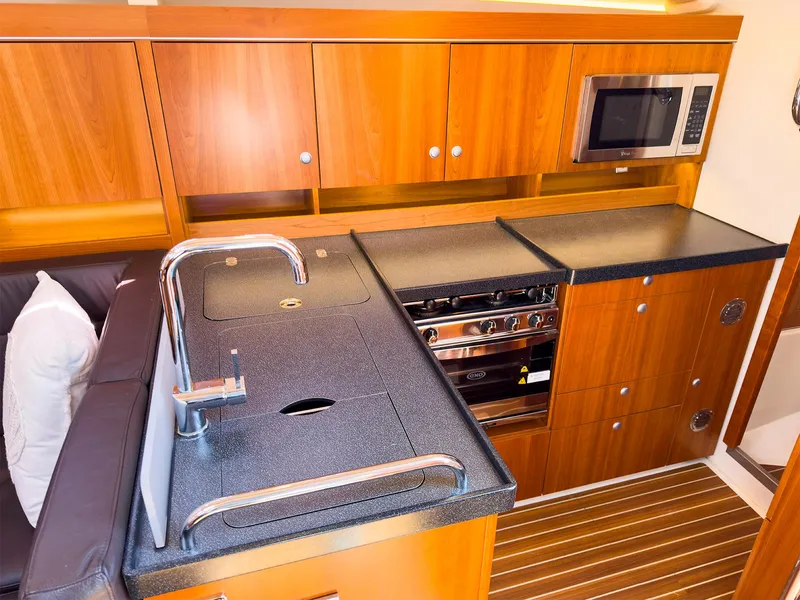 Slide: The Image of Modern galley kitchen in 2014 Hanse 445 sailboat with wood cabinetry and black countertops. - 24