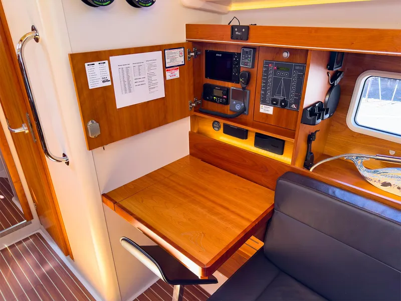 Slide: The Image of Navigation station on 2014 Hanse 445 sailboat with wooden desk and control panels. - 26