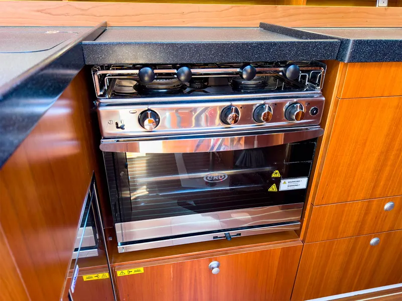Slide: The Image of Modern kitchen stove in 2014 Hanse 445 yacht with wooden cabinetry. - 27