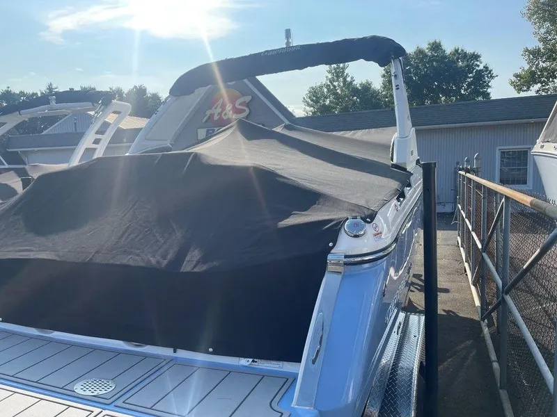 Slide: The Image of 2024 Chaparral 267 SSX boat with cover in marina, sunny day. - 11