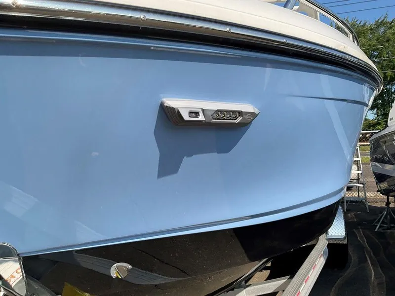 Slide: The Image of 2024 Chaparral 267 SSX boat, blue hull, docked on trailer. - 13