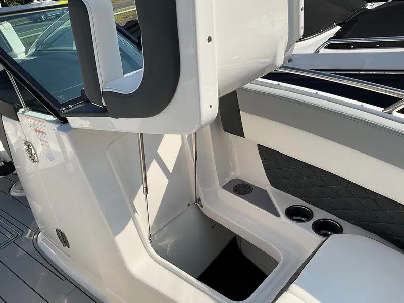 Slide: The Image of 2024 Chaparral 267 SSX boat interior with storage compartment and cup holders. - 22