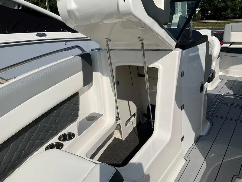 Slide: The Image of 2024 Chaparral 267 SSX boat interior with open storage compartment and seating area. - 23