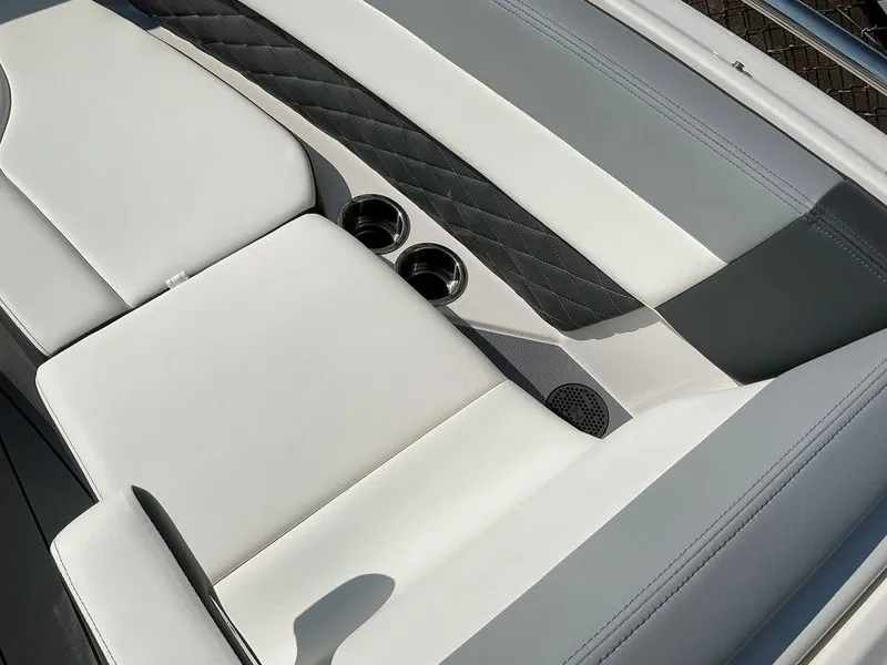 Slide: The Image of 2024 Chaparral 267 SSX boat interior with sleek white and gray seating and cup holders. - 26