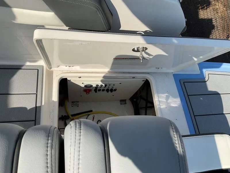 Slide: The Image of 2024 Chaparral 267 SSX boat storage compartment with open hatch and visible controls. - 43