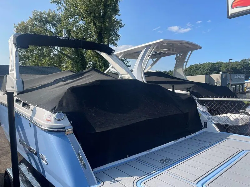 Slide: The Image of 2024 Chaparral 267 SSX boat with black cover, parked outdoors. - 9