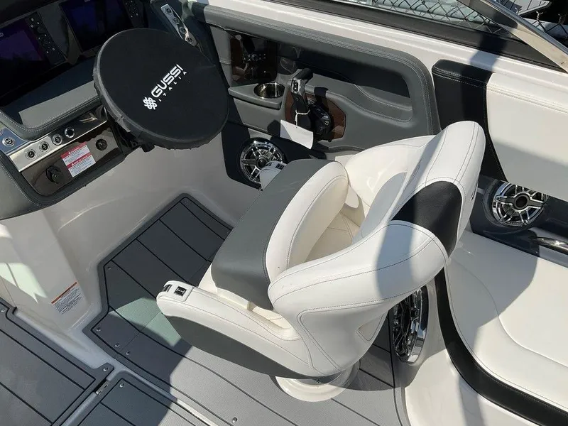 Slide: The Image of 2024 Chaparral 270 OSX boat cockpit with steering wheel and captain's chair. - 13