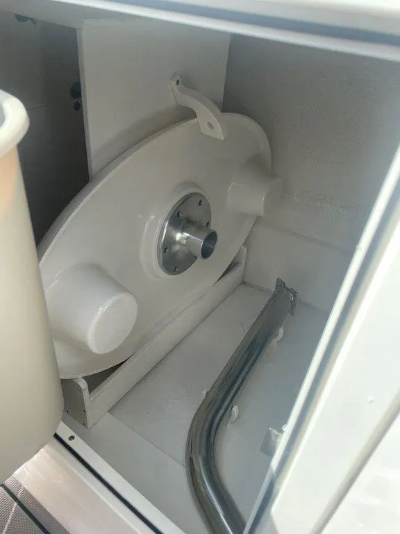 Slide: The Image of 2024 Chaparral 270 OSX boat storage compartment with metal and plastic components. - 18