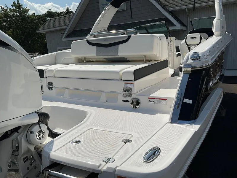 Slide: The Image of 2024 Chaparral 270 OSX boat, rear view, showcasing spacious deck and seating area. - 21