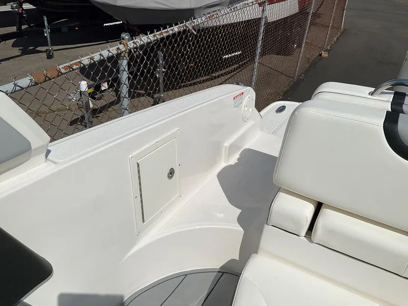 Slide: The Image of 2024 Chaparral 270 OSX boat interior with white seating and storage compartment. - 24