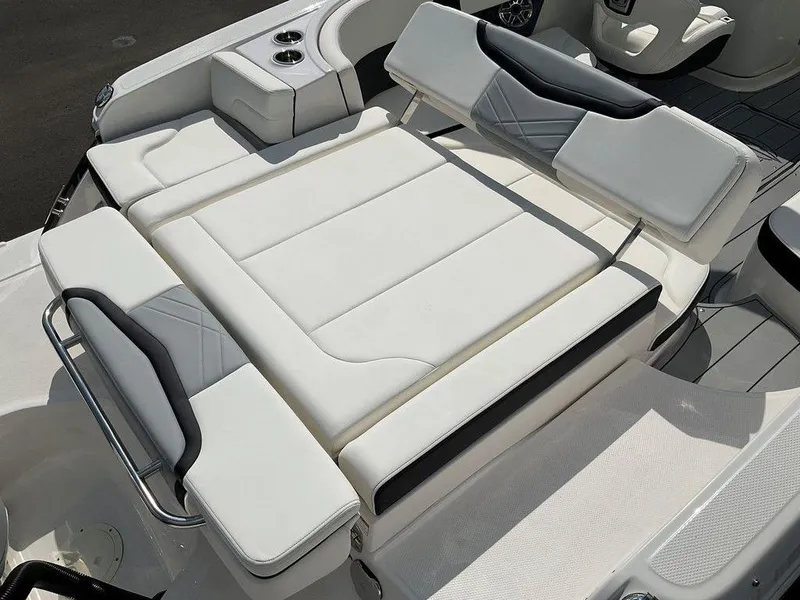 Slide: The Image of 2024 Chaparral 270 OSX boat interior with white cushioned seating and cup holders. - 25