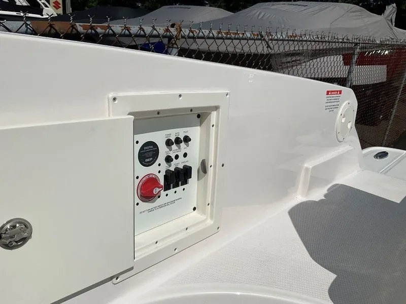 Slide: The Image of Control panel on 2024 Chaparral 270 OSX boat, featuring switches and a red dial. - 26