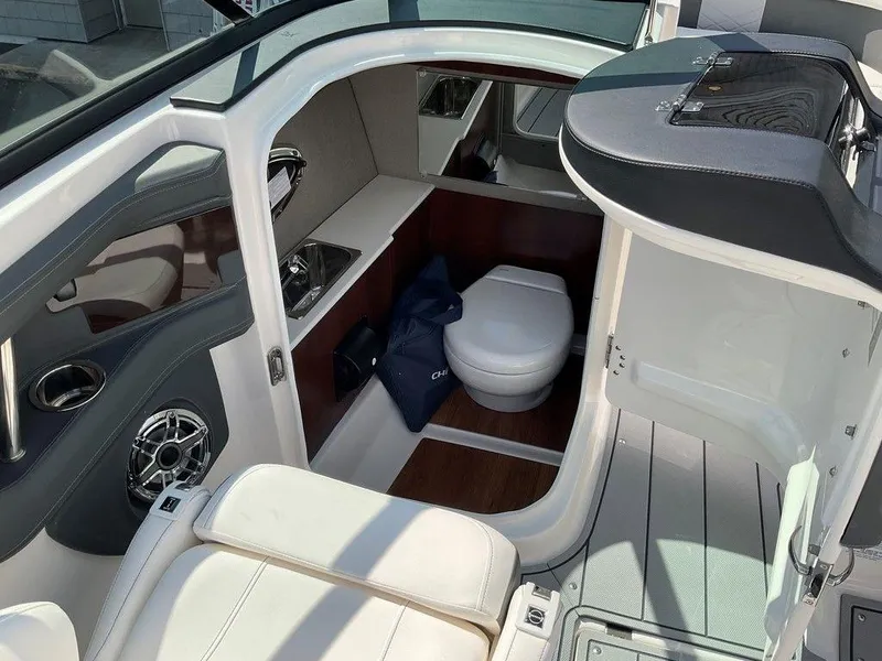 Slide: The Image of 2024 Chaparral 270 OSX boat interior with compact bathroom and seating area. - 36