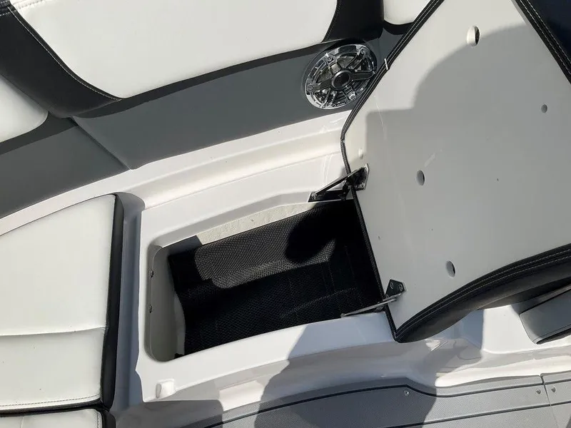 Slide: The Image of 2024 Chaparral 270 OSX boat storage compartment with open lid and speaker detail. - 40