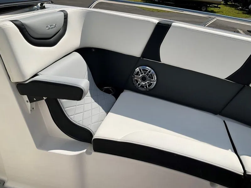 Slide: The Image of 2024 Chaparral 270 OSX boat interior with black and white seating and speaker detail. - 44