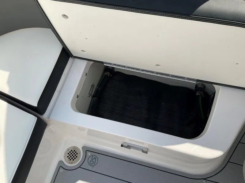 Slide: The Image of 2024 Chaparral 270 OSX storage compartment with open lid, showcasing interior space. - 47