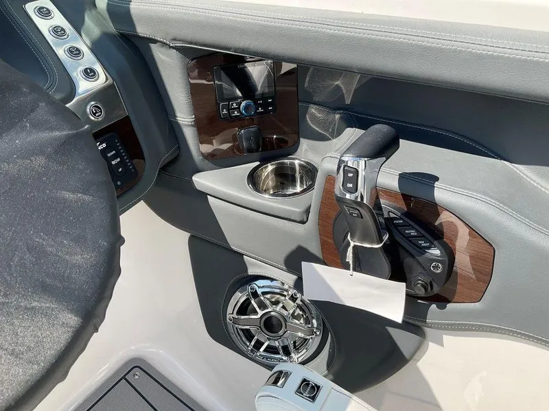 Slide: The Image of 2024 Chaparral 270 OSX boat cockpit with controls, cup holder, and speaker. - 6