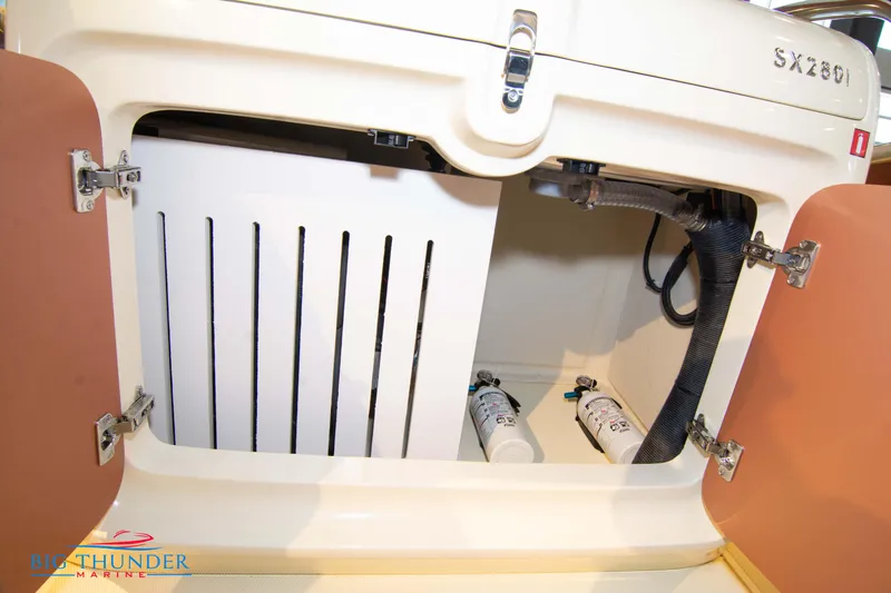 Slide: The Image of 2024 Capoforte SX280I boat storage compartment with visible hoses and filters. - 21