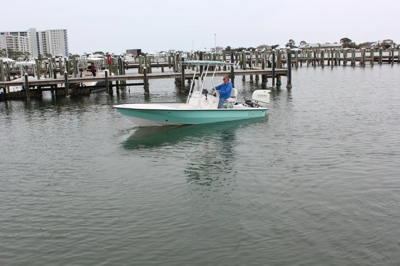 Slide: The Image of 2019 Wagner Catamaran Coaches boat in a marina with docks and buildings in the background. - 4