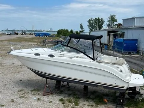 Slide: The Image of 2001 Sea Ray 260 Sundancer boat on dry dock near industrial area. - 17