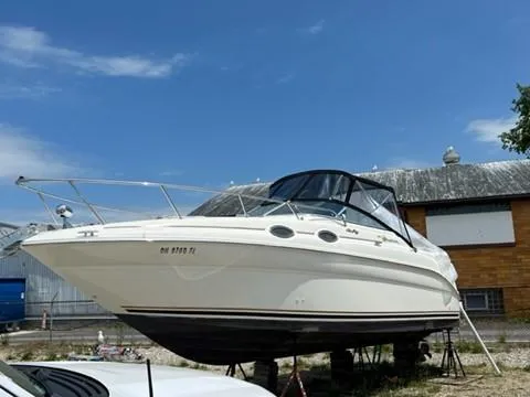 Slide: The Image of 2001 Sea Ray 260 Sundancer boat on stands under a clear blue sky. - 18