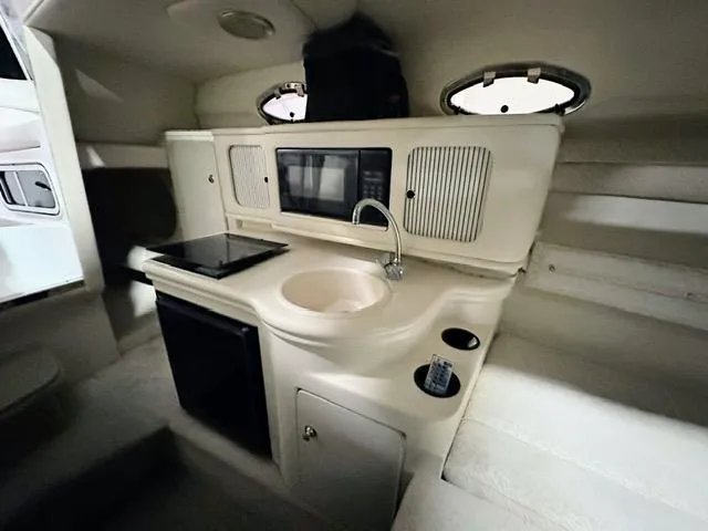 Slide: The Image of 2001 Sea Ray 260 Sundancer boat interior kitchen with sink, microwave, and stove. - 5