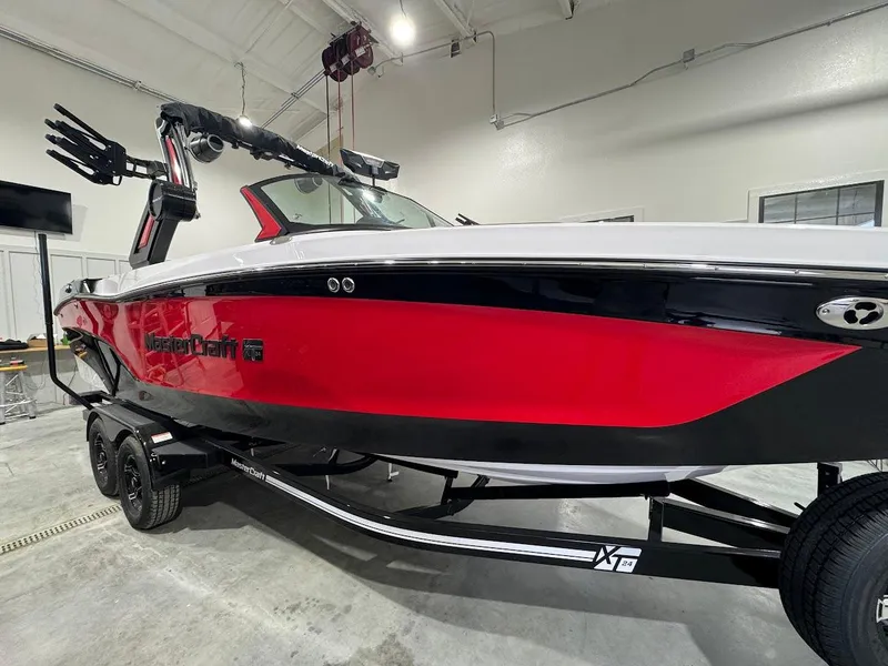 Slide: The Image of 2024 MasterCraft XT24 boat in red and black, displayed indoors. - 10