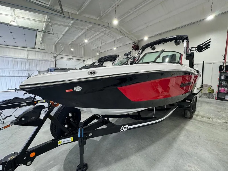 Slide: The Image of 2024 MasterCraft XT24 boat in a showroom, red and black exterior. - 12