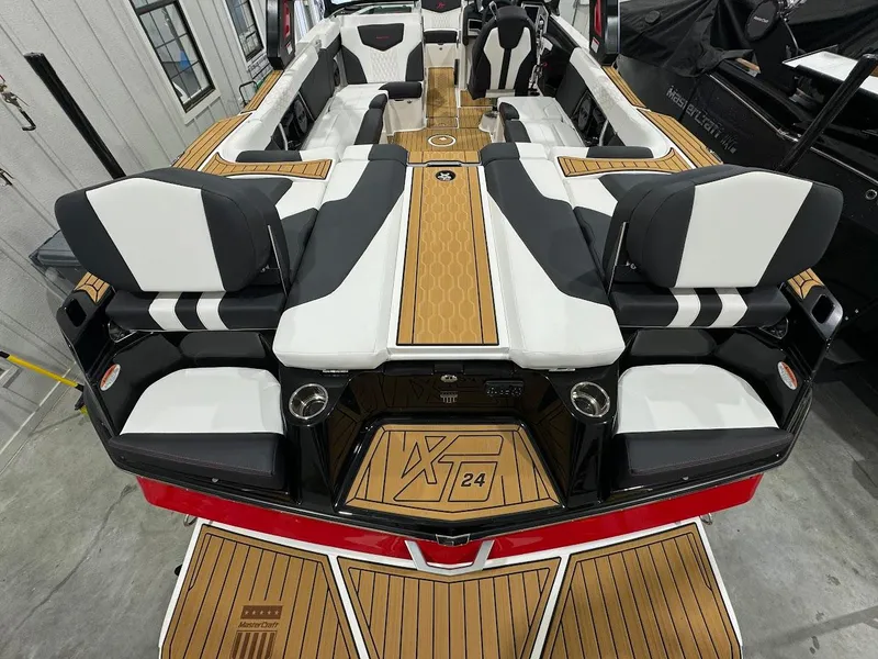 Slide: The Image of 2024 MasterCraft XT24 boat interior with luxurious seating and teak flooring. - 13