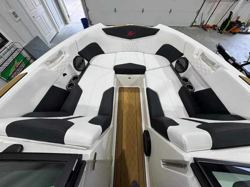 Slide: The Image of 2024 MasterCraft XT24 boat interior with white and black seating. - 19