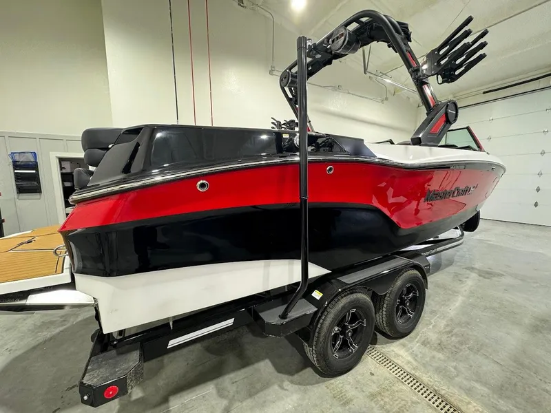Slide: The Image of 2024 MasterCraft XT24 boat in red, black, and white on a trailer in a garage. - 9