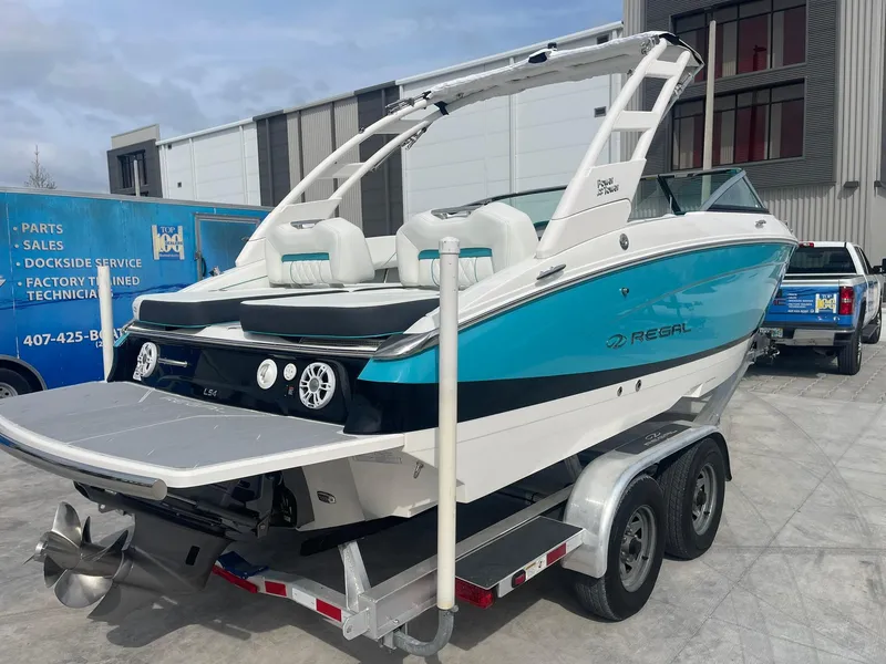 Slide: The Image of 2024 Regal LS4 boat on a trailer, rear view, in a marina. - 1