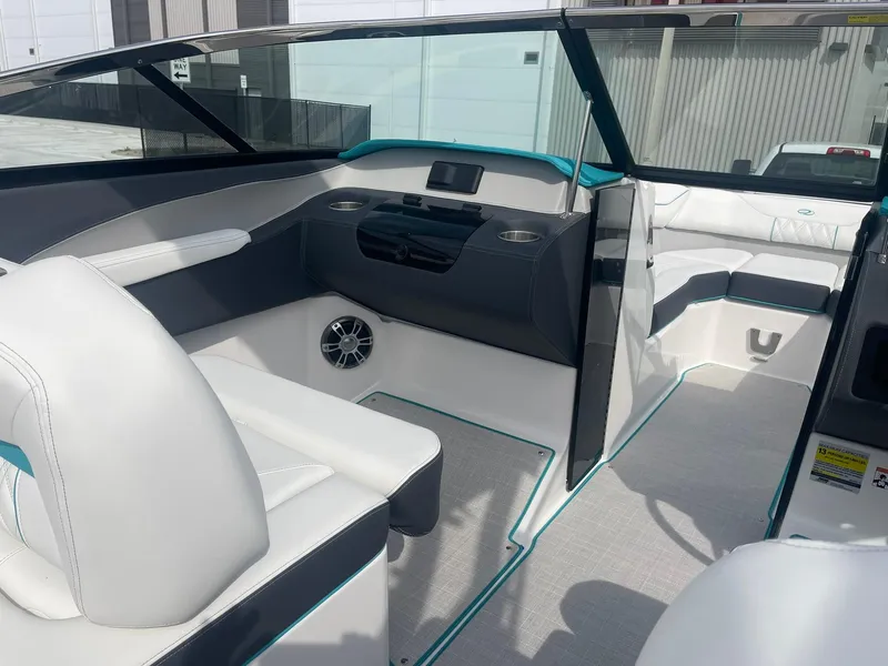 Slide: The Image of 2024 Regal LS4 boat interior with white and gray seating, modern dashboard, and speaker system. - 10